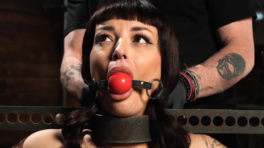Ball gag stuffed in Charlie Valentine's mouth while her